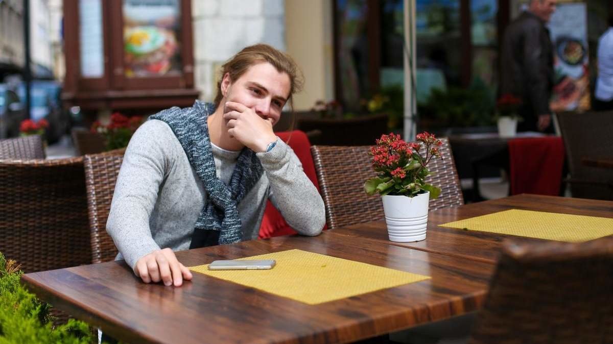 Persona con autismo sentada en la terraza de un restaurante - Foto de 123RF/sisterspro