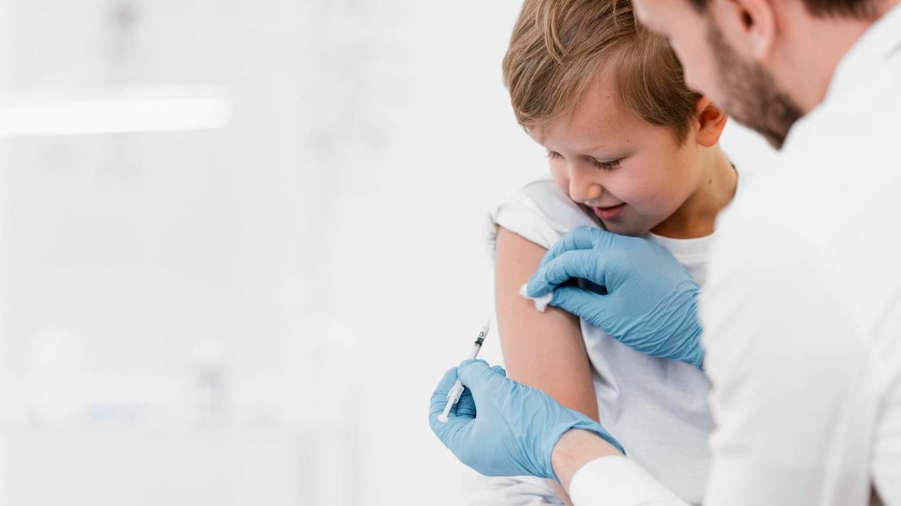 Médico de primer plano vacunando a niño - Freepik