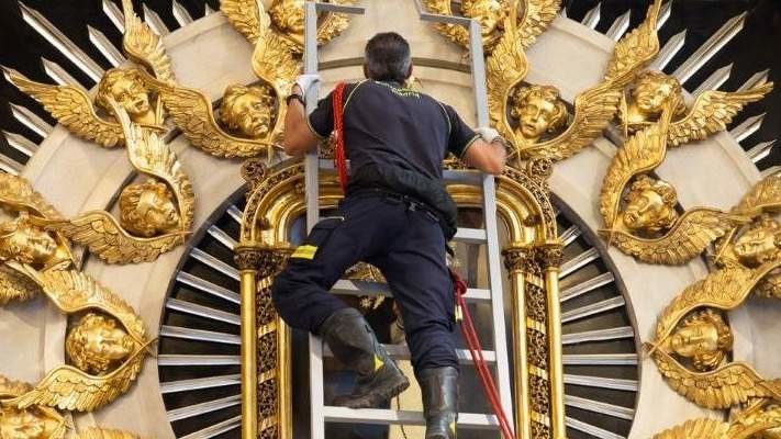 Un bombero ante el cuadro de la Virgen de la Paloma - Foto de Archimadrid