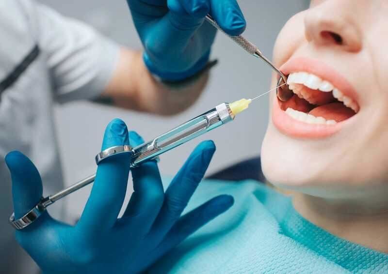 Dentista pinchando anestesia a un paciente - Getty Images